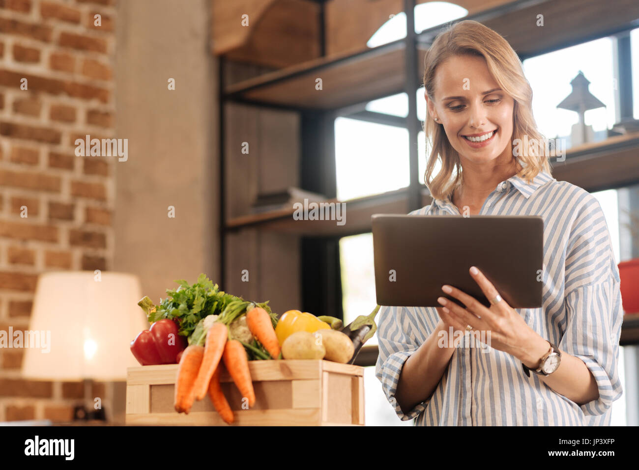 Charismatische hingegebene Frau auf der Suche nach dem richtigen Rezept Stockfoto