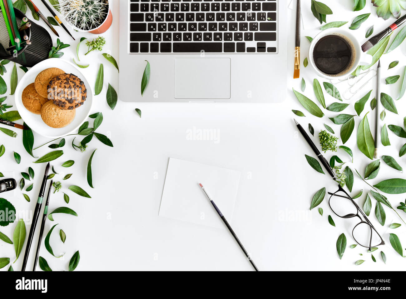 Draufsicht des Laptops, Büromaterial und Kaffee am Arbeitsplatz isoliert auf weiß, drahtlose Kommunikations-Konzept Stockfoto
