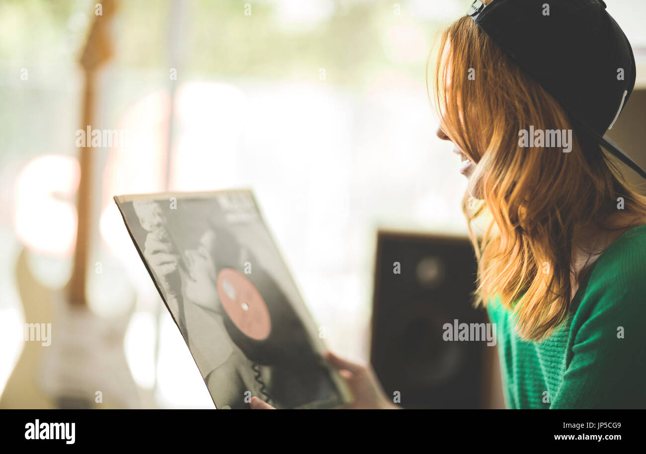 Eine Frau betrachtet ein Plattencover. Stockfoto