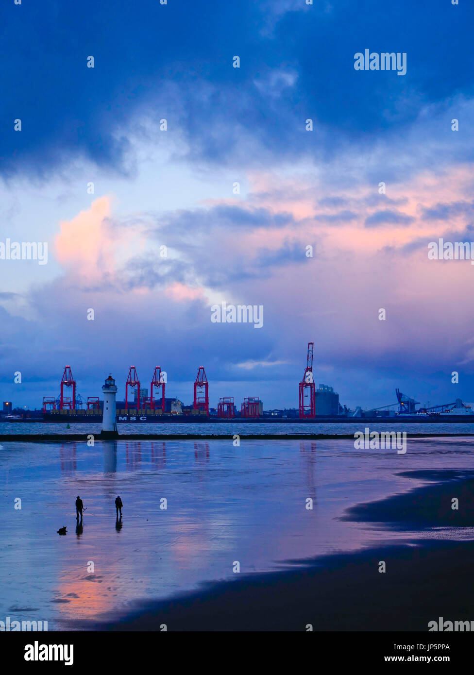 Riesige Kräne bei Liverpool zwei Container-Hafen vor dem Hintergrund der dramatischen Abendhimmel mit Reflexionen in den Fluss Mersey bei Ebbe gezeigt. Stockfoto