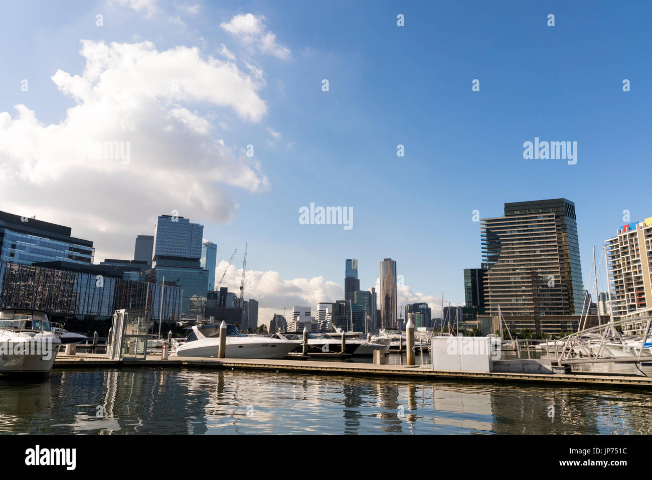 Docklands, Melbourne, Victoria, Australien. Gebäude am Wasser und Marina, Wasser und Glas Sekt in der Sonne. Stockfoto