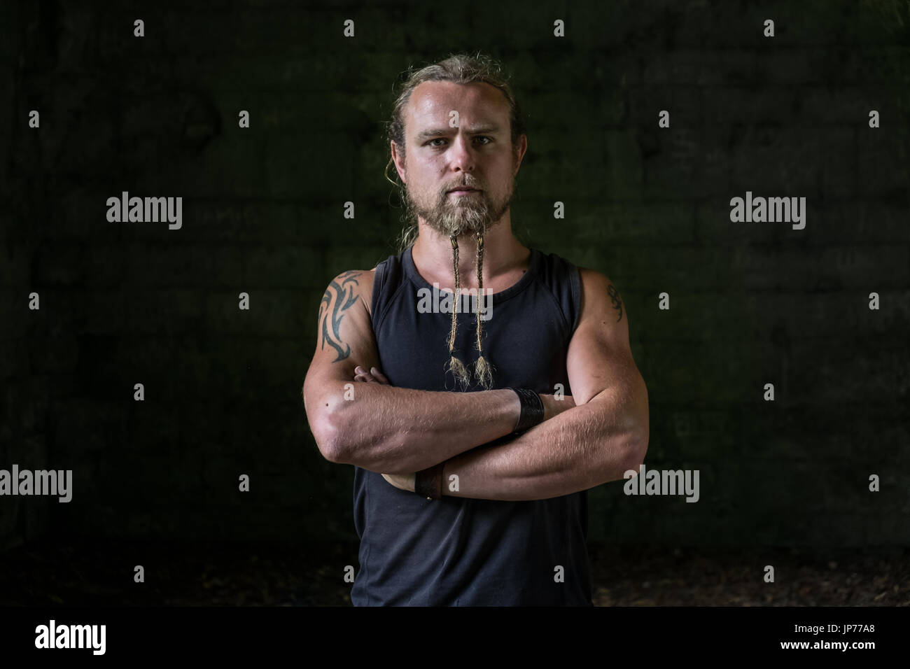 Mittelalterlicher Krieger Soldat Reenactment junger Mann mit langen Haaren, geflochten, Bart und tattoo Stockfoto