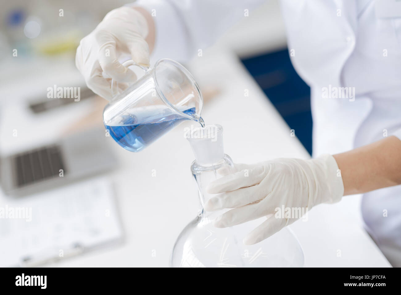 Nahaufnahme von Flüssigkeit in die Flasche gegossen wird Stockfoto