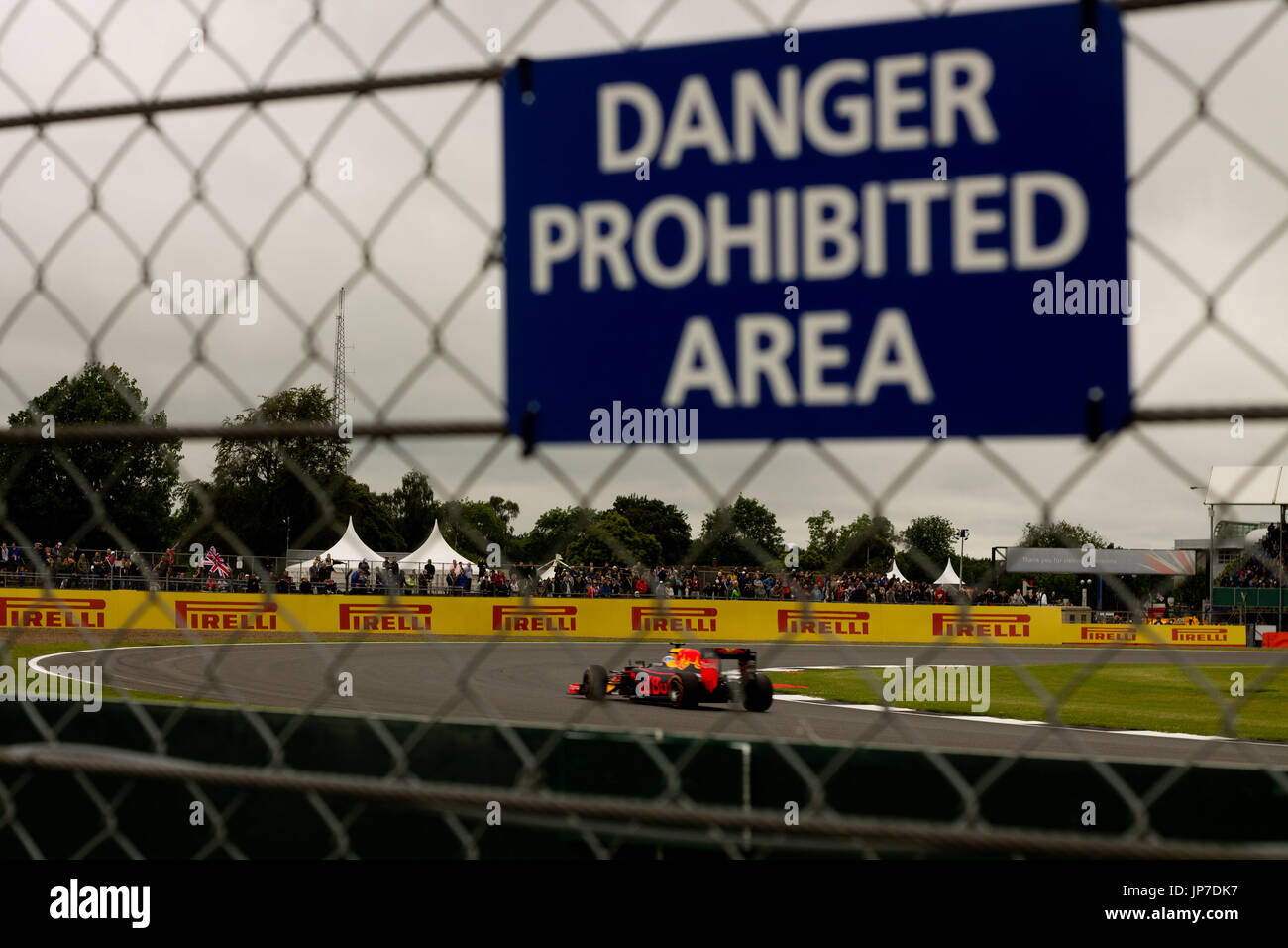Daniel Ricciardo an Luffield Ecke am Grand Prix von Silverstone Circuit hinter einem Zaun Zuschauer mit einem Warnhinweis Stockfoto