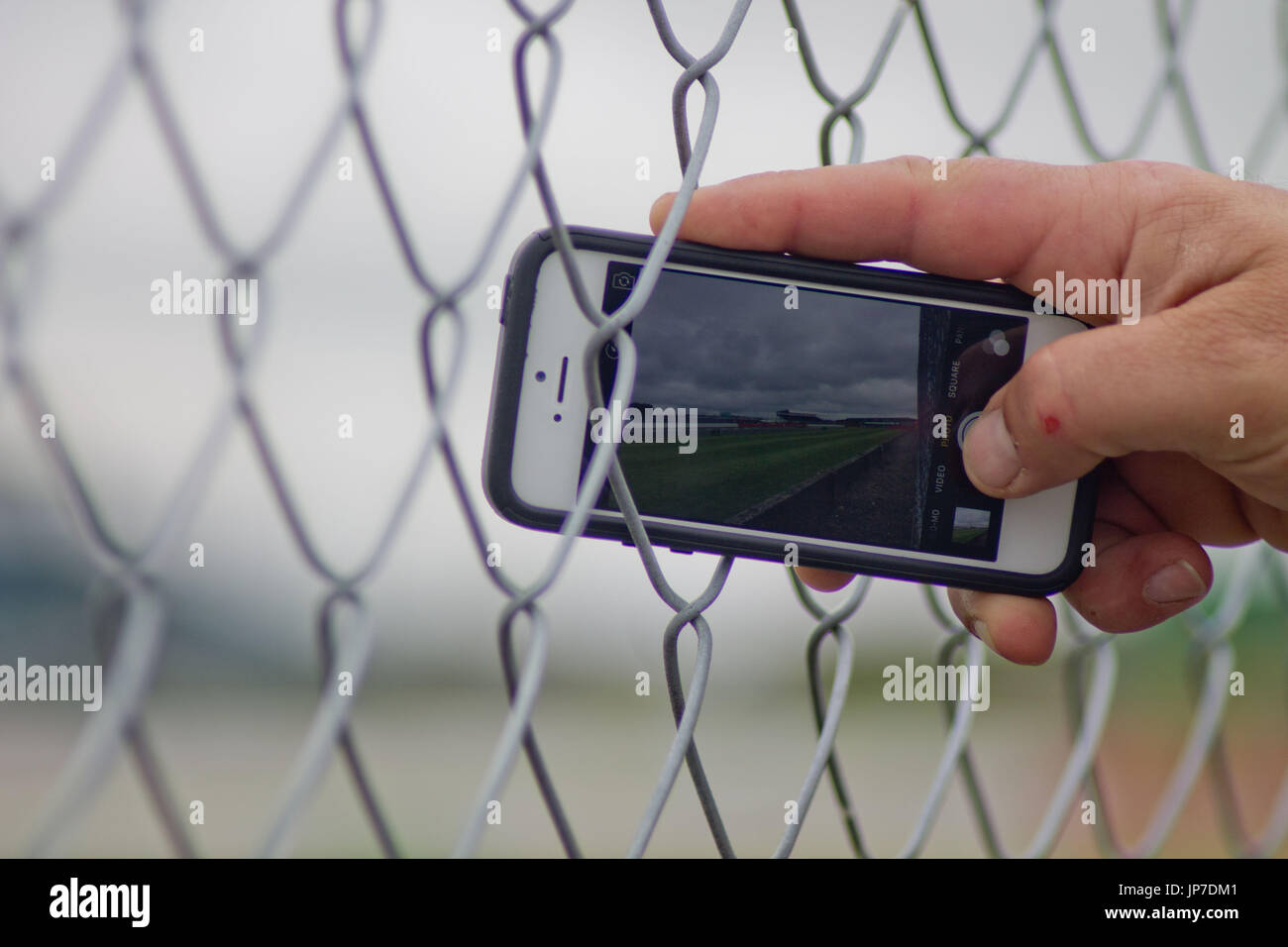 Ein Zuschauer Filme Formel1 Autos g Vergangenheit seines iPhone 6 Stockfoto