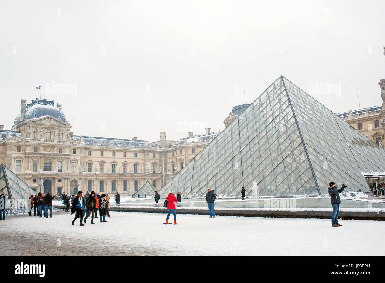 Paris, Schnee - Menschen genießen einen winter schnee Tag rund um den Louvre. Stockfoto