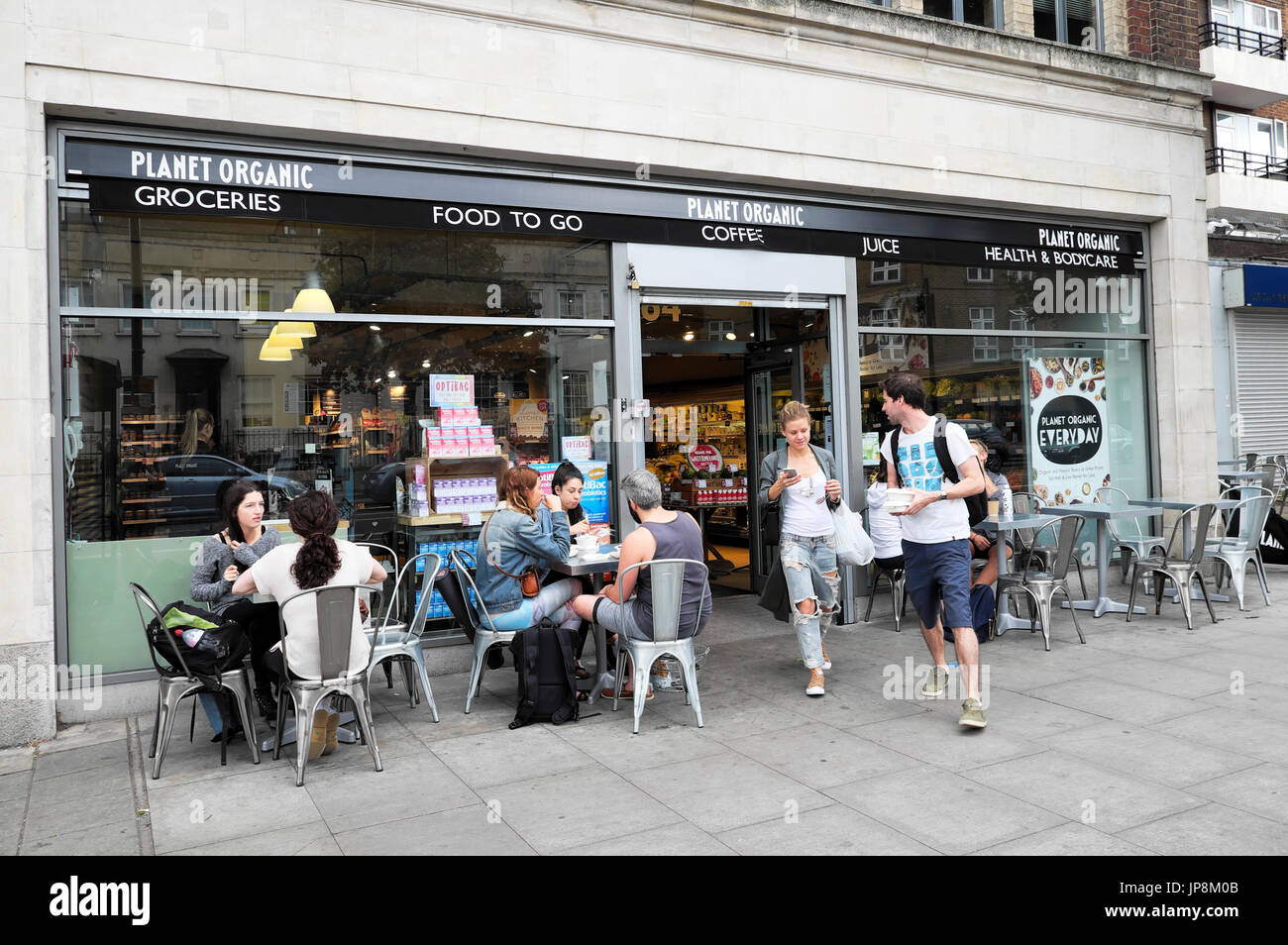 Leute sitzen an Tischen im freien Planeten Supermarkt Naturkostladen in Essex Road in London N1 UK KATHY DEWITT Essen trinken Stockfoto