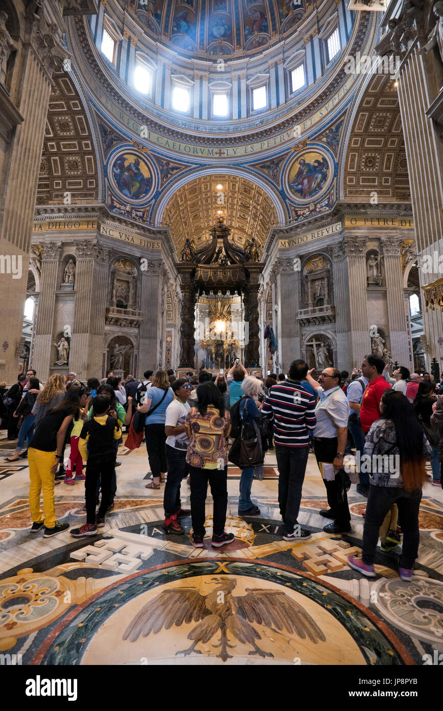 Vertikale Ansicht von Touristen lokking bei St. Peter Grab in der Basilika St. Peter im Vatikan in Rom. Stockfoto