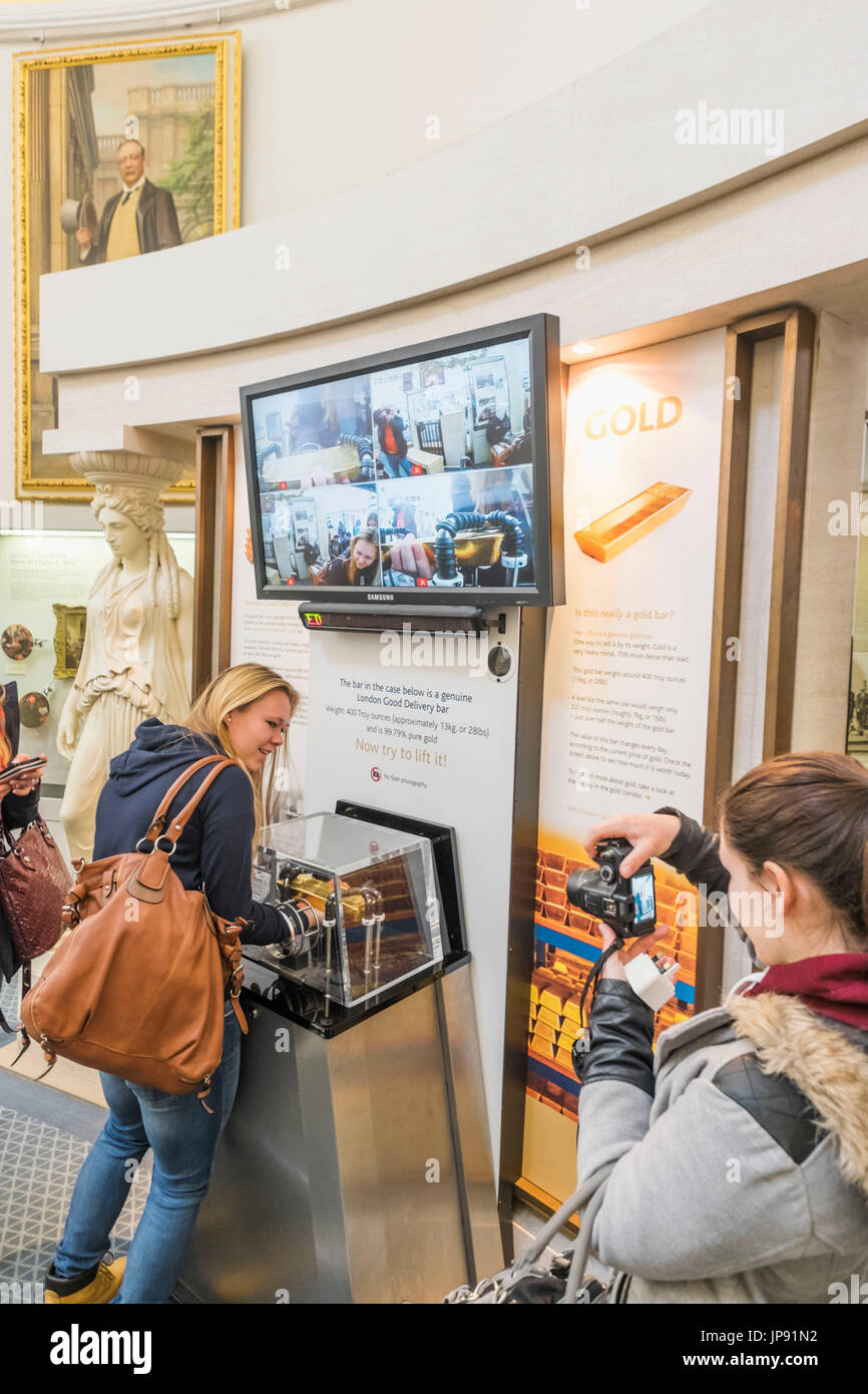 England, London, die Stadt, Bank of England Museum, Besucher heben Solid Gold Bar Stockfoto