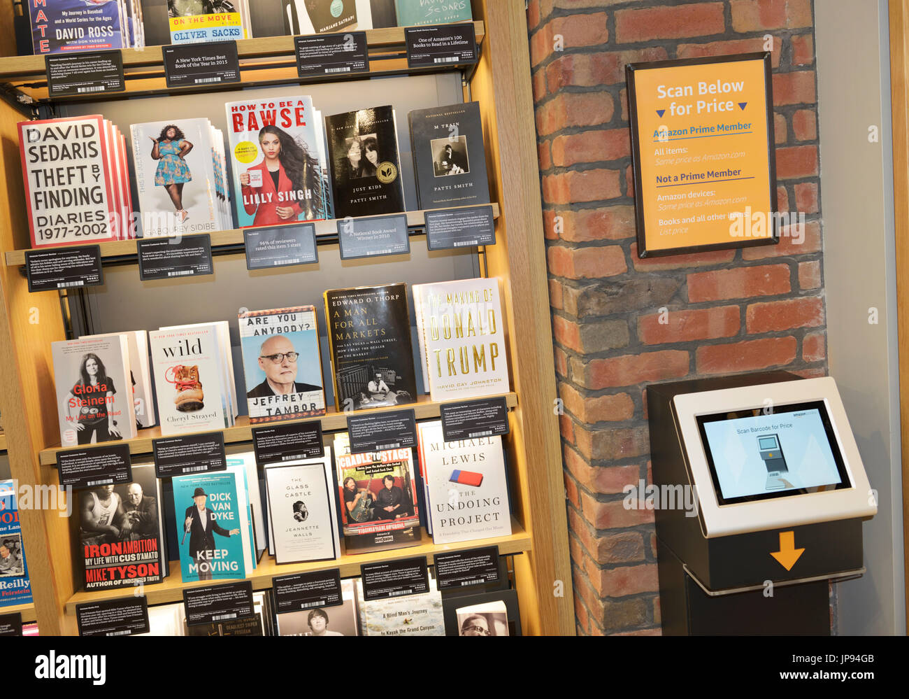 Bücherreihen in einer Amazon Bücher Einzelhandel zu speichern, mit einem Bildschirm für ein Preisvergleich zu scannen Stockfoto