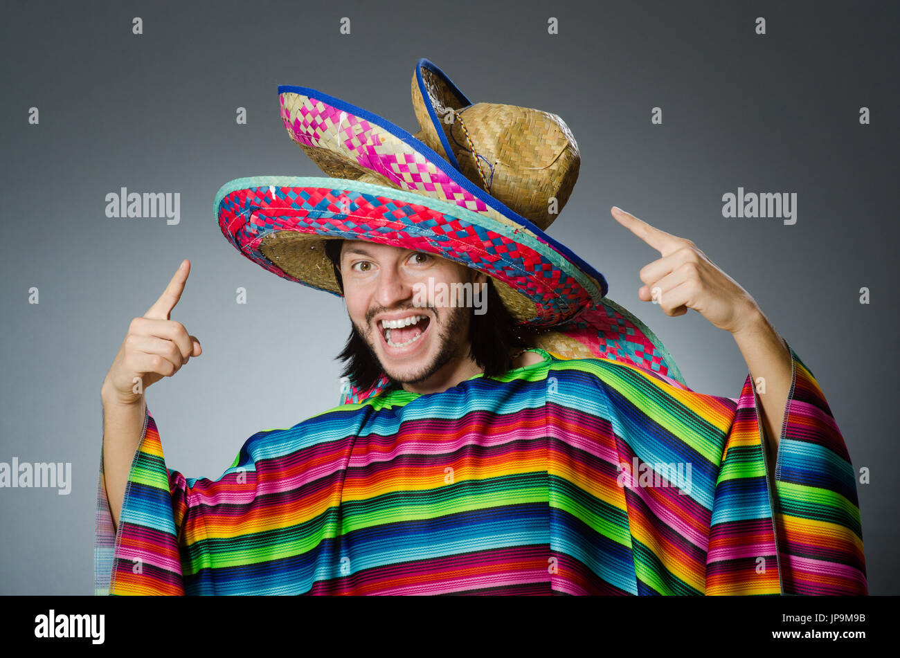 Mann in einem lebendigen mexikanischen Poncho grauen Hintergrund isoliert Stockfoto