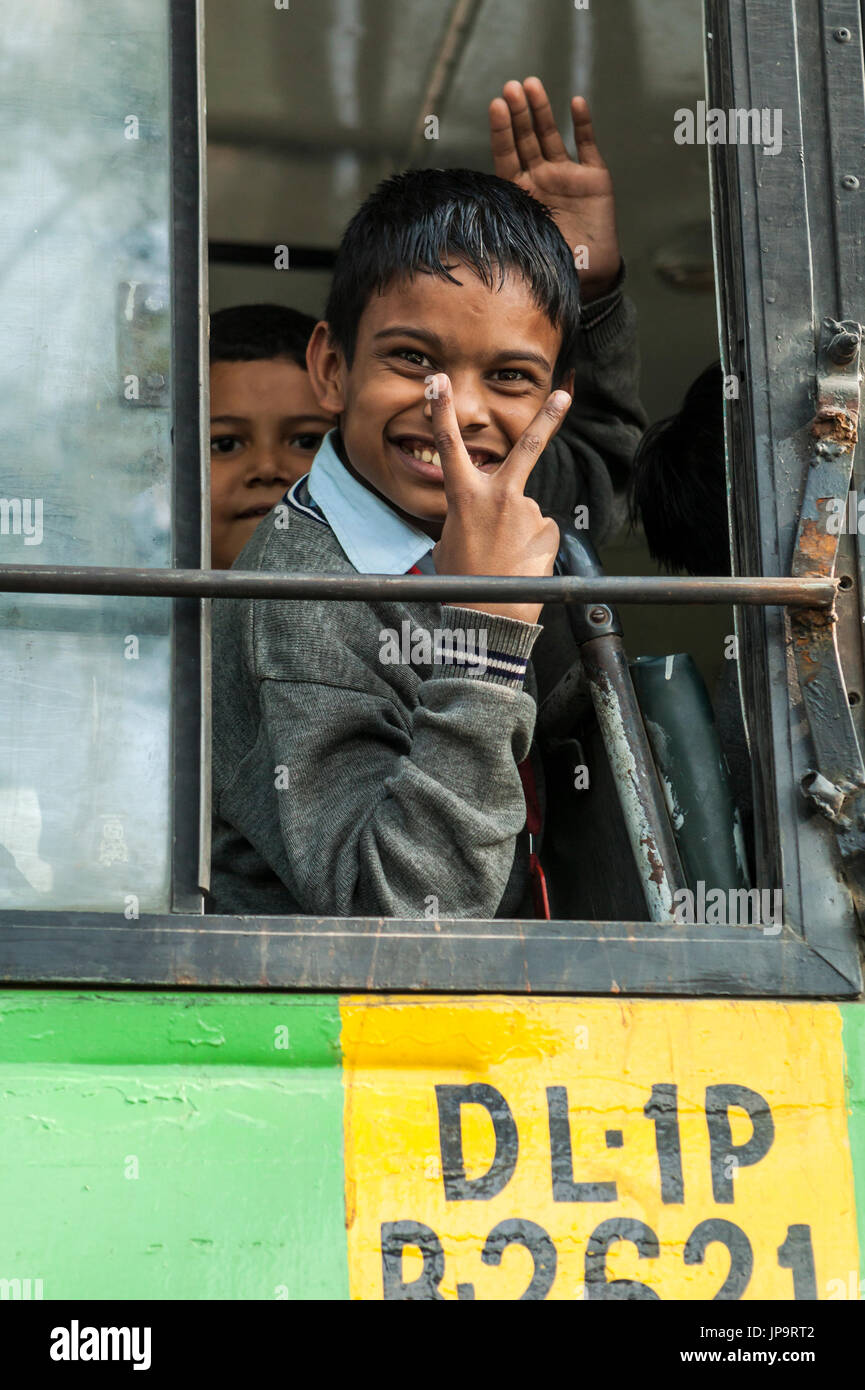 Ein Junge in das offene Fenster eines Schulbusses, Delhi, Indien. Stockfoto