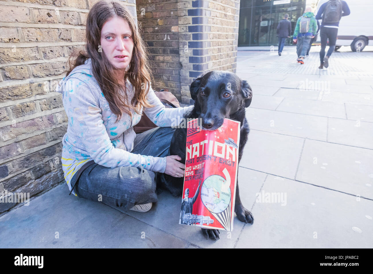 England, London, Obdachlose Mädchen mit Hund Verkauf des Magazins großes Problem Stockfoto