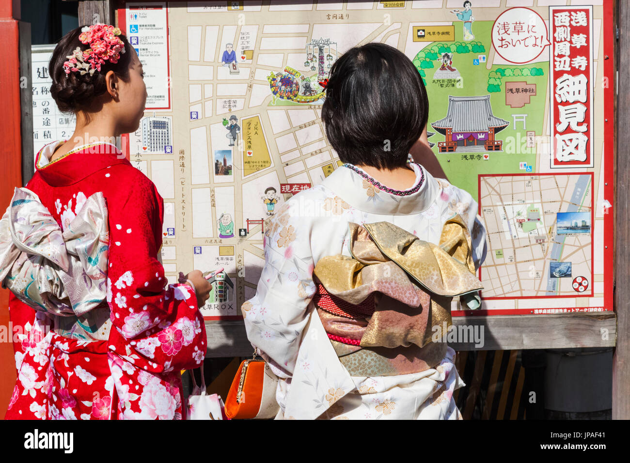 Japan, Honshu, Tokio, Asakusa, Mädchen im Kimono Blick auf Karte Stockfoto