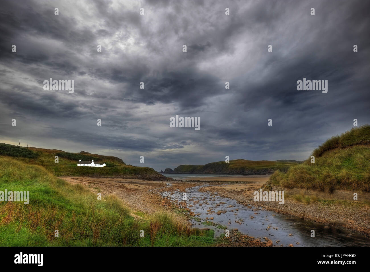 Einsame Haus in einem Meer Bucht im schottischen Hochland, ein kleiner Bach führen zum Meer. Stockfoto