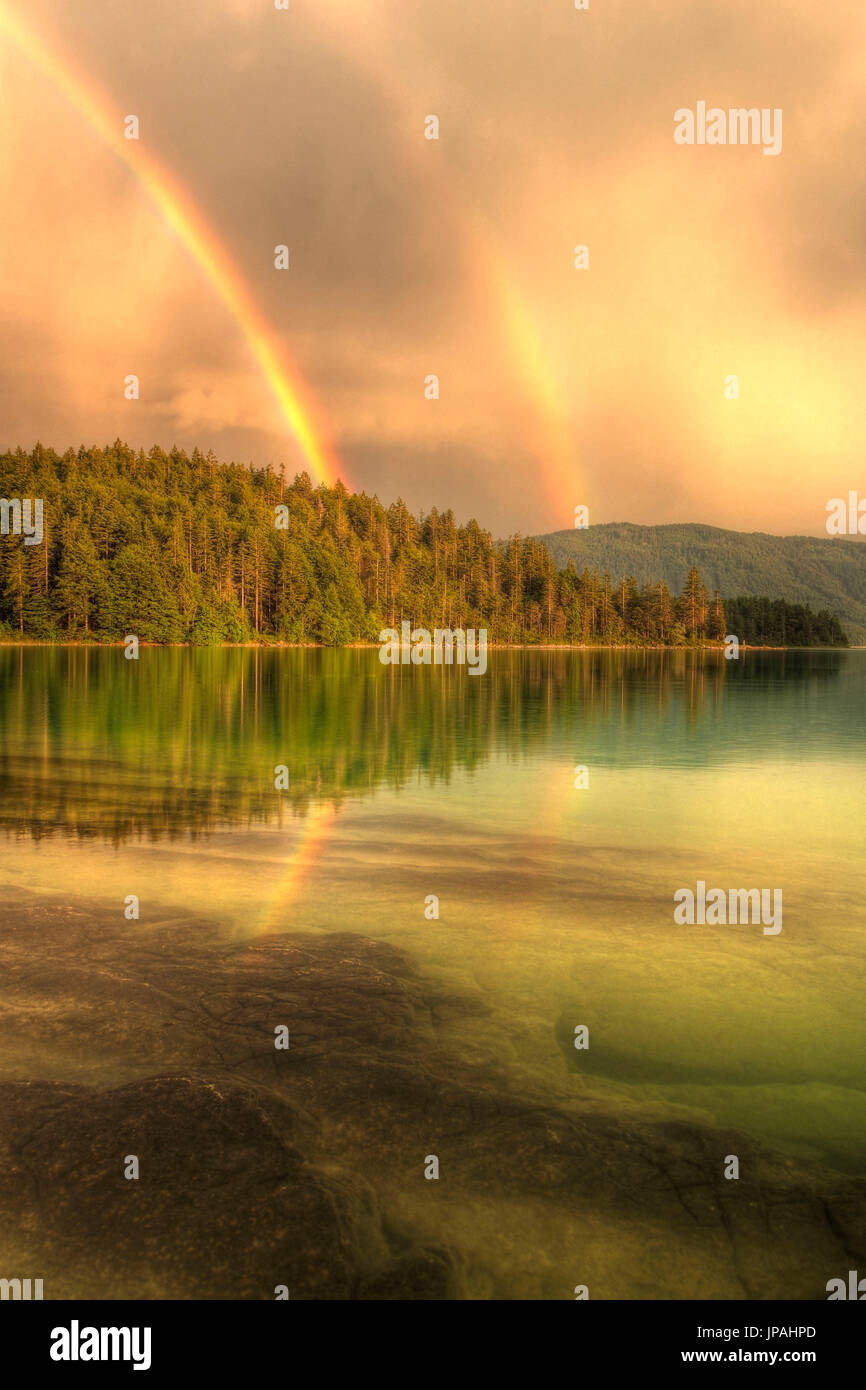 HDR-Aufnahme von einem doppelten Regenbogen über das klare Wasser des Walchensee. Stockfoto