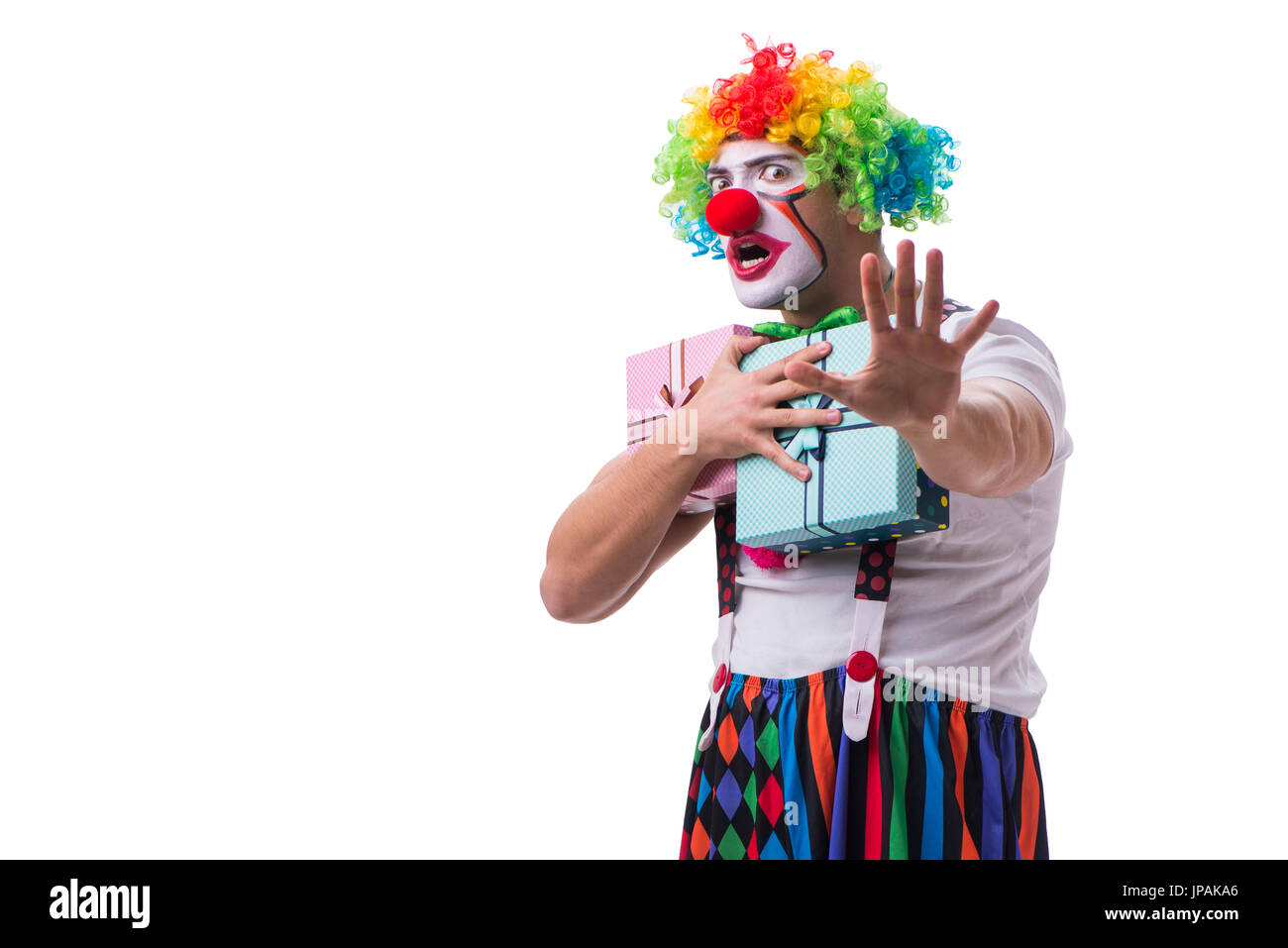 Lustiger Clown mit einer vorliegenden Geschenkbox isoliert auf weißem Hintergrund Stockfoto