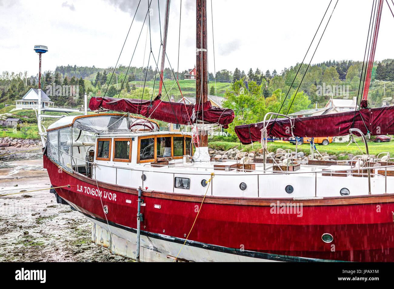 Port-au-Persil, Kanada-2. Juni 2017: Pier und Hafen mit roten Schiff und melden Sie La Toison D'Or im Dorf von Quebec in Charlevoix Region während der stürmischen r Stockfoto