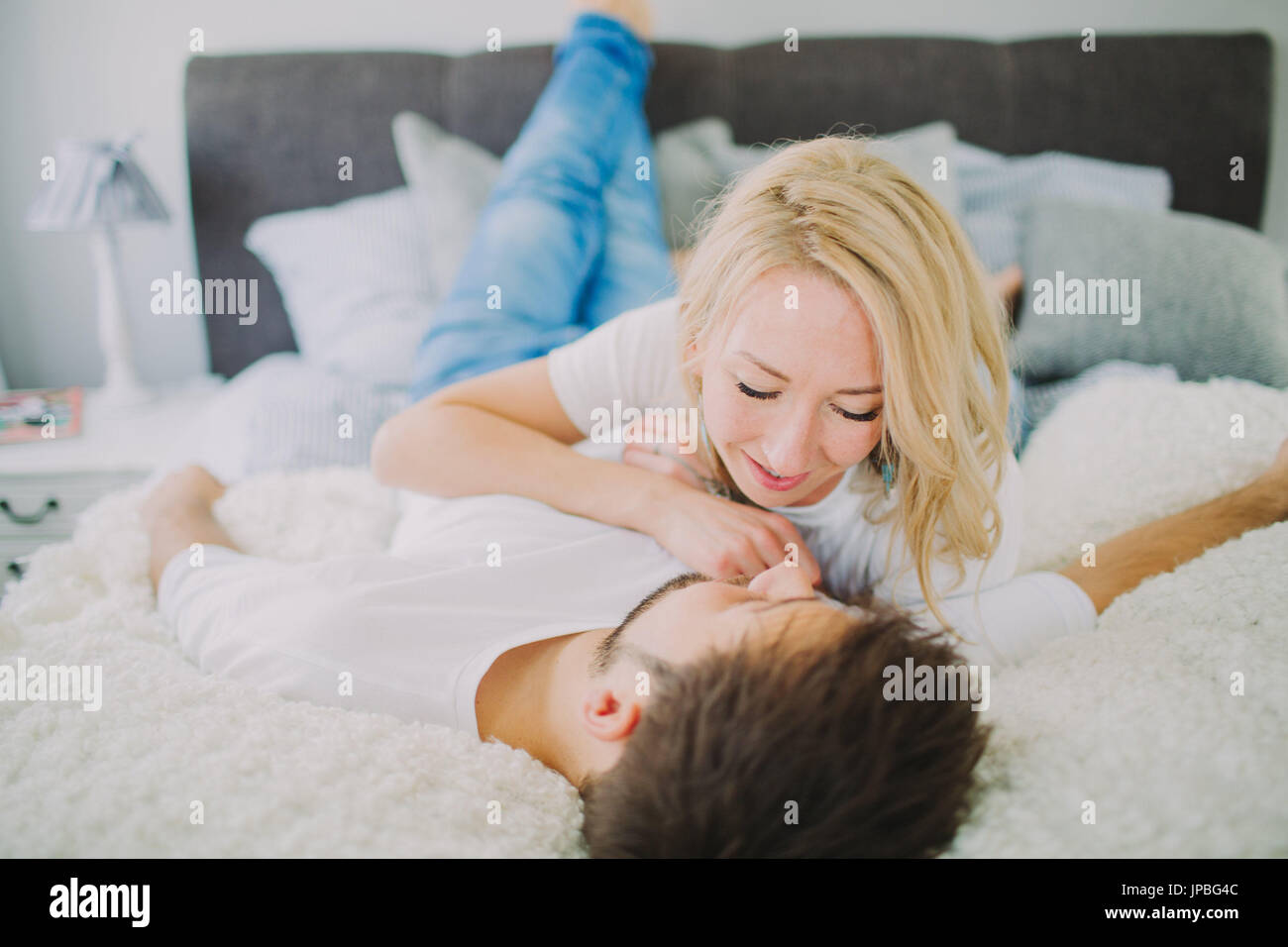 Junges Paar in Liebe zu Hause im Bett Stockfoto