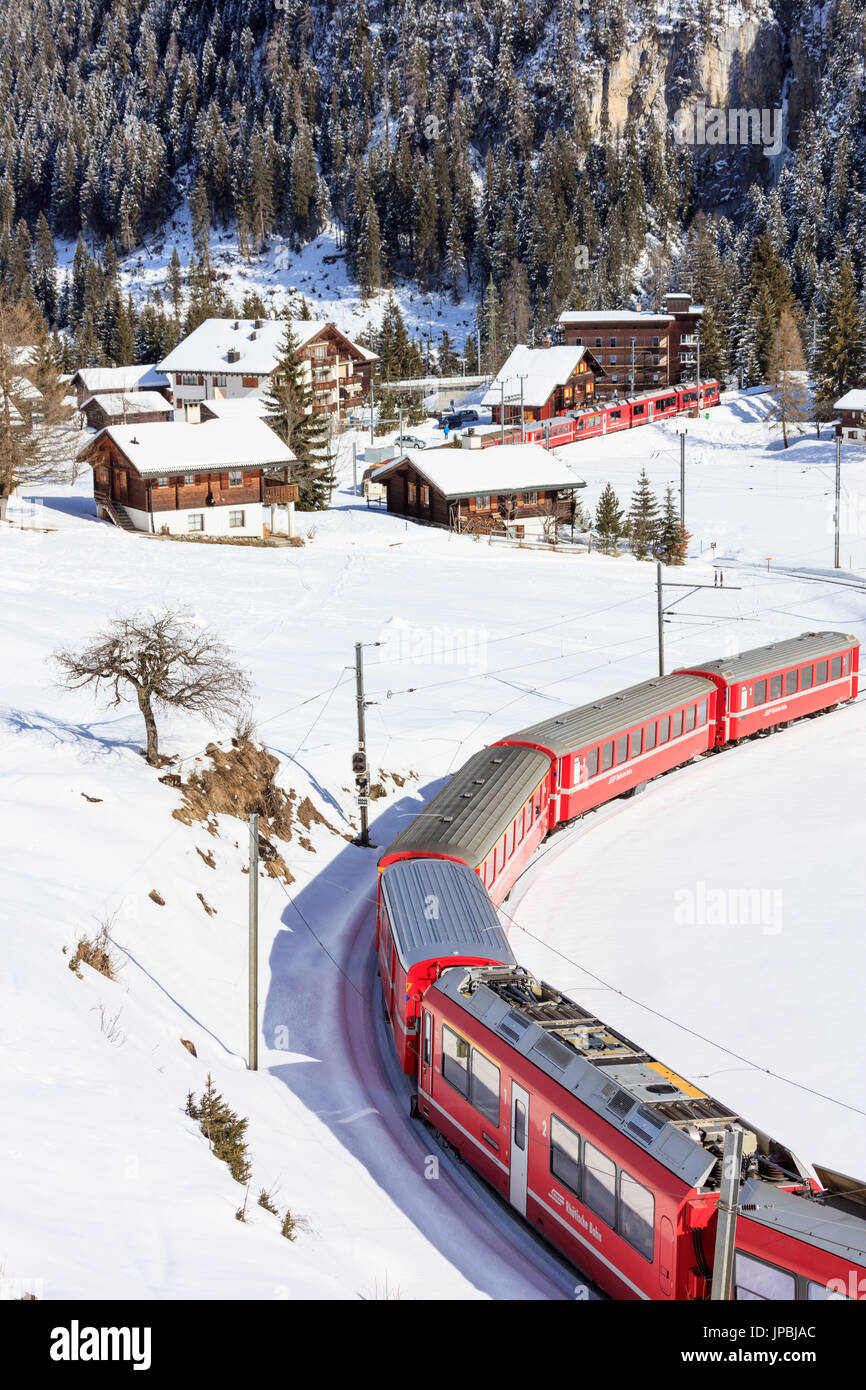 Roter Zug der Rhätischen Bahn geht in die verschneite Landschaft von Arosa Bezirk Plessur Kanton Graubünden-Schweiz-Europa Stockfoto