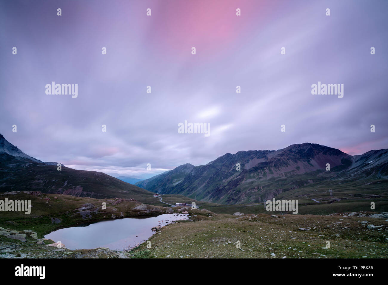 Laghetto Alto Scorluzzo umrahmt von rosa Wolken im Morgengrauen Bormio Braulio Tal Valtellina Lombardei Italien Europa Stockfoto