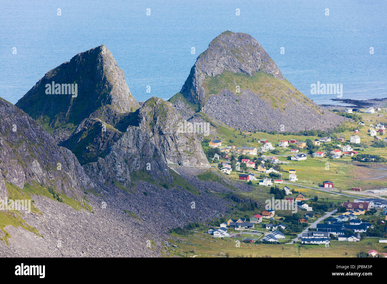 Felsige Gipfel umrahmen das Dorf Sorland, umgeben von Meer Vaeroy Insel Nordland county Lofoten Inselgruppe Norwegen Europa Stockfoto