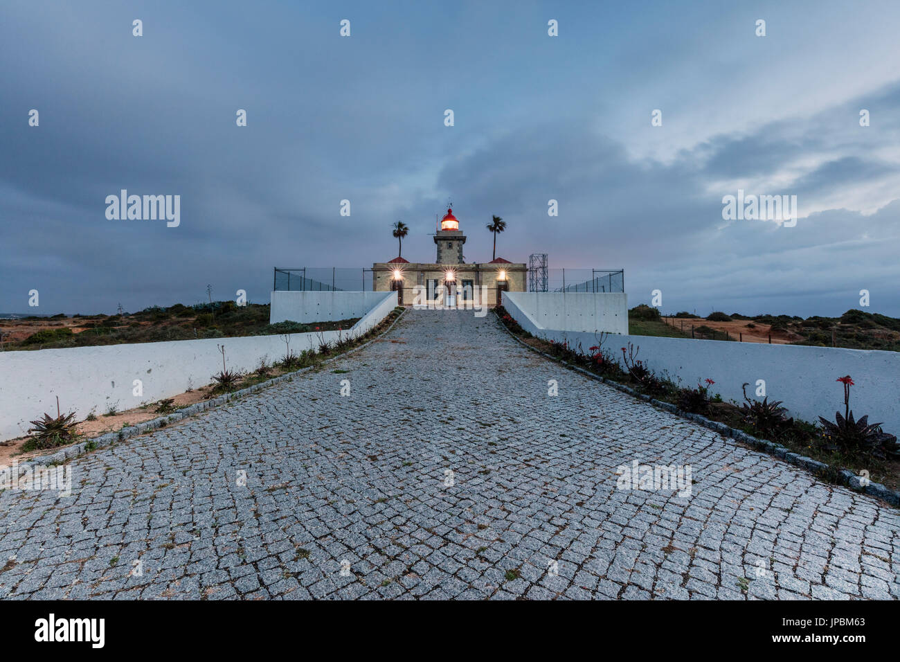 Dämmerung leuchten die den Leuchtturm, umgeben von den Atlantischen Ozean Ponta Da Piedade Lagos Algarve Portugal Europa Stockfoto