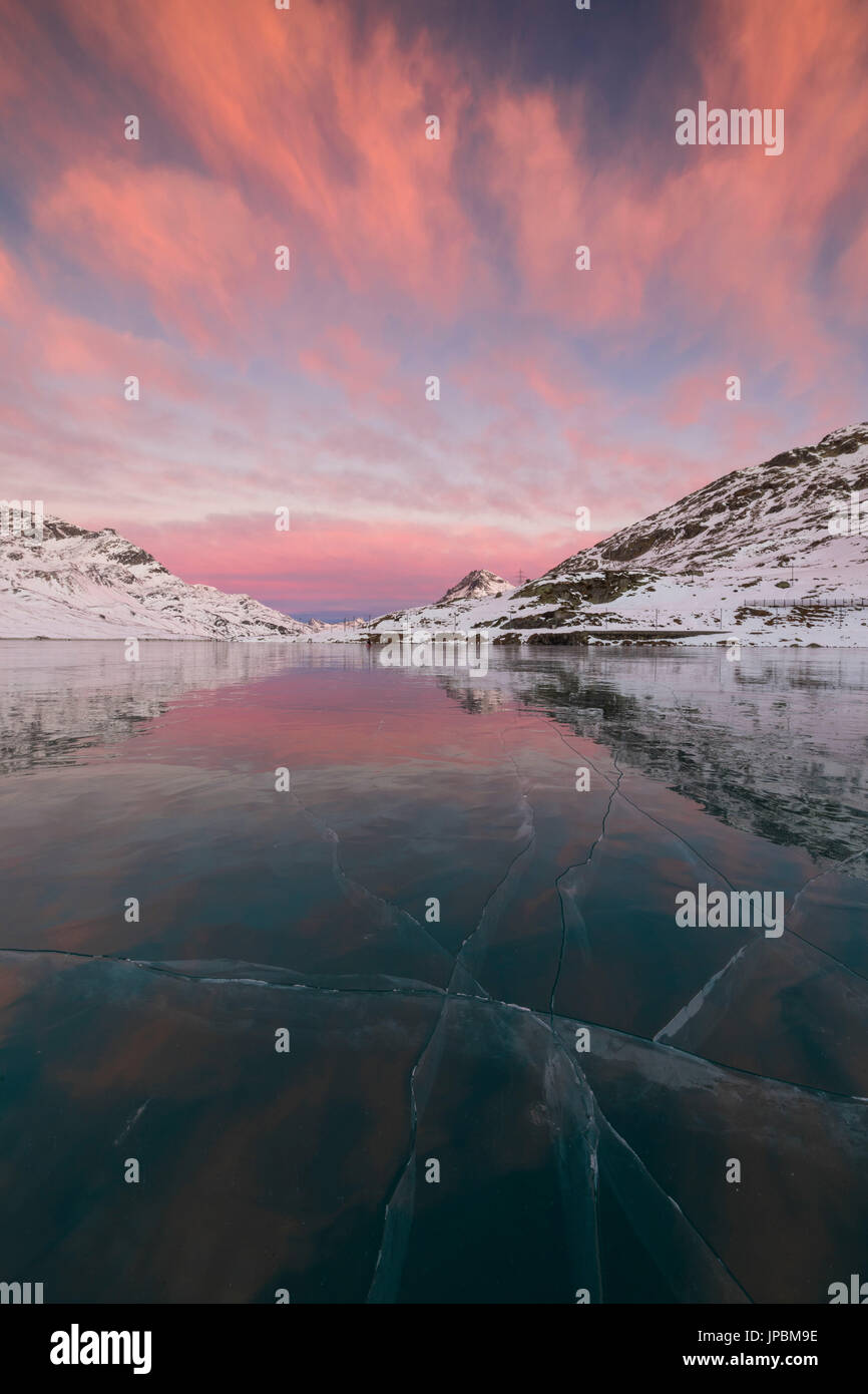 Die gefrorenen Lago Bianco umrahmt von rosa Wolken im Morgengrauen Berninapass Kanton Graubünden-Engadin-Schweiz-Europa Stockfoto