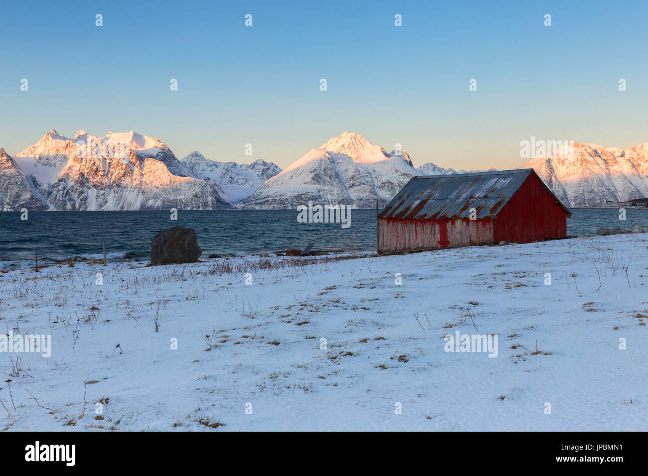 Traditionelles rotes Haus mit Blick auf den Fjord. Hammarvika, Lyngenfjord, Lyngen Alpen, Troms, Norwegen, Lappland, Europas. Stockfoto