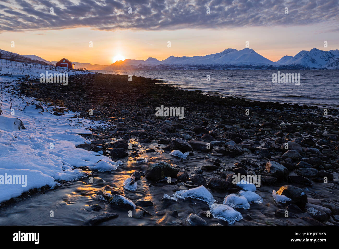 Die Sonne geht hinter den Lyngen-Alpen. Nordmannvik, Kafjord, Lyngen Alpen, Troms, Norwegen, Lappland, Europas. Stockfoto