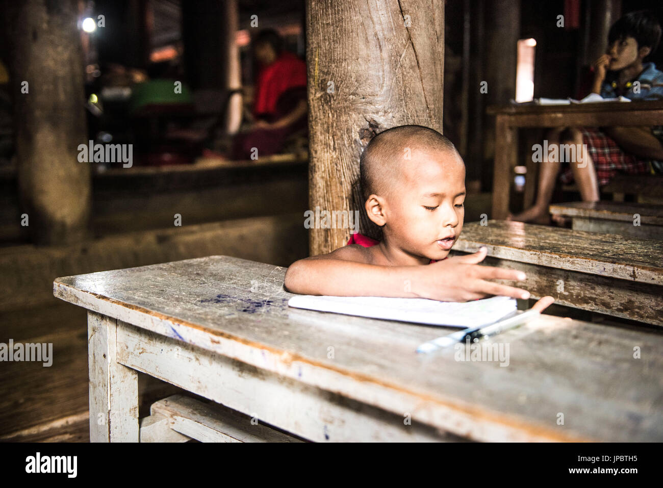 Inwa, Region Mandalay, Myanmar (Burma). Ein junger Mönch in das Bagaya Kyaung Kloster zu studieren. Stockfoto