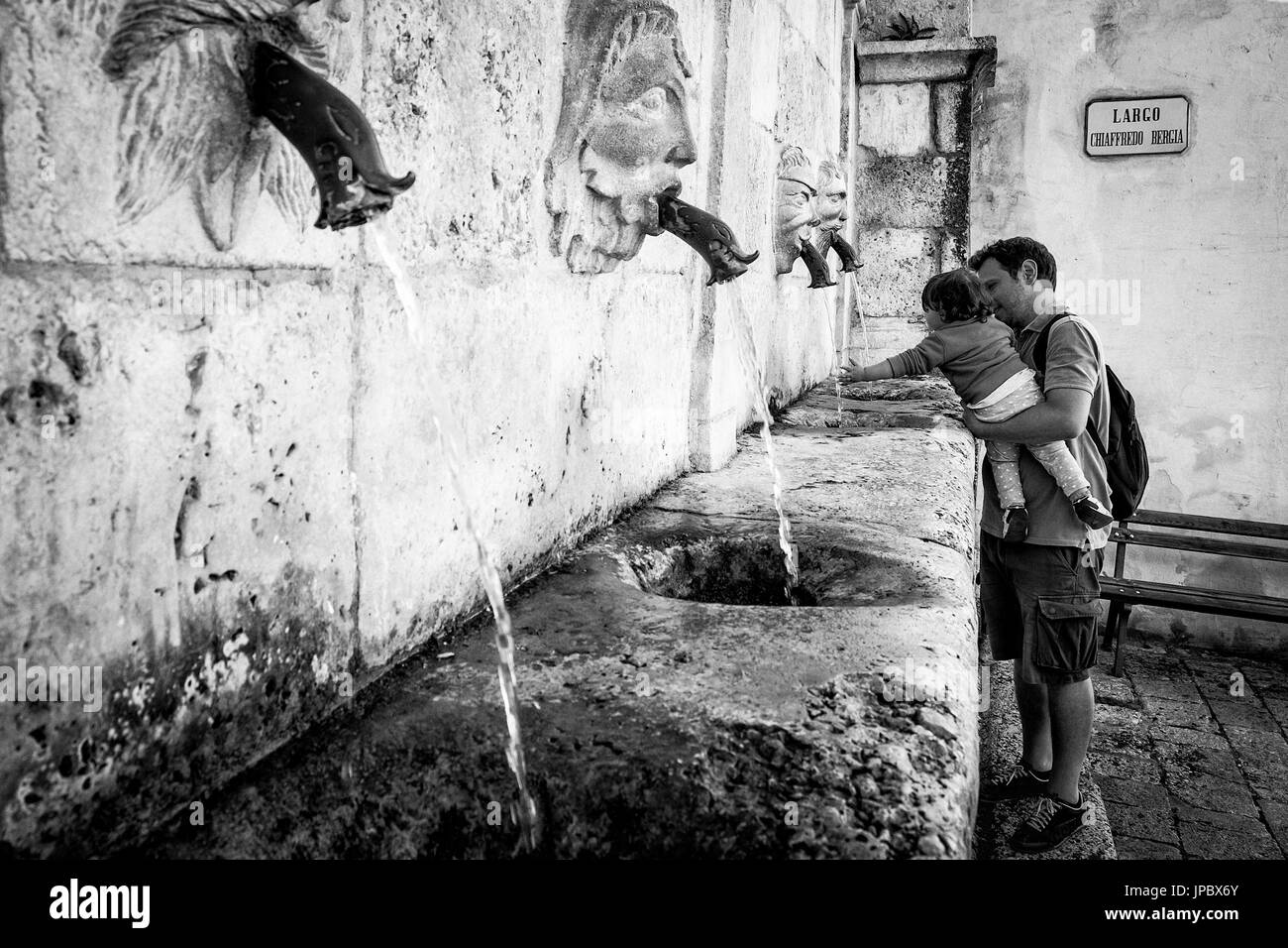 Scanno, Abruzzen, Italien, Europa. Erfrischung am Sarracco Brunnen in schwarz und weiß. Stockfoto