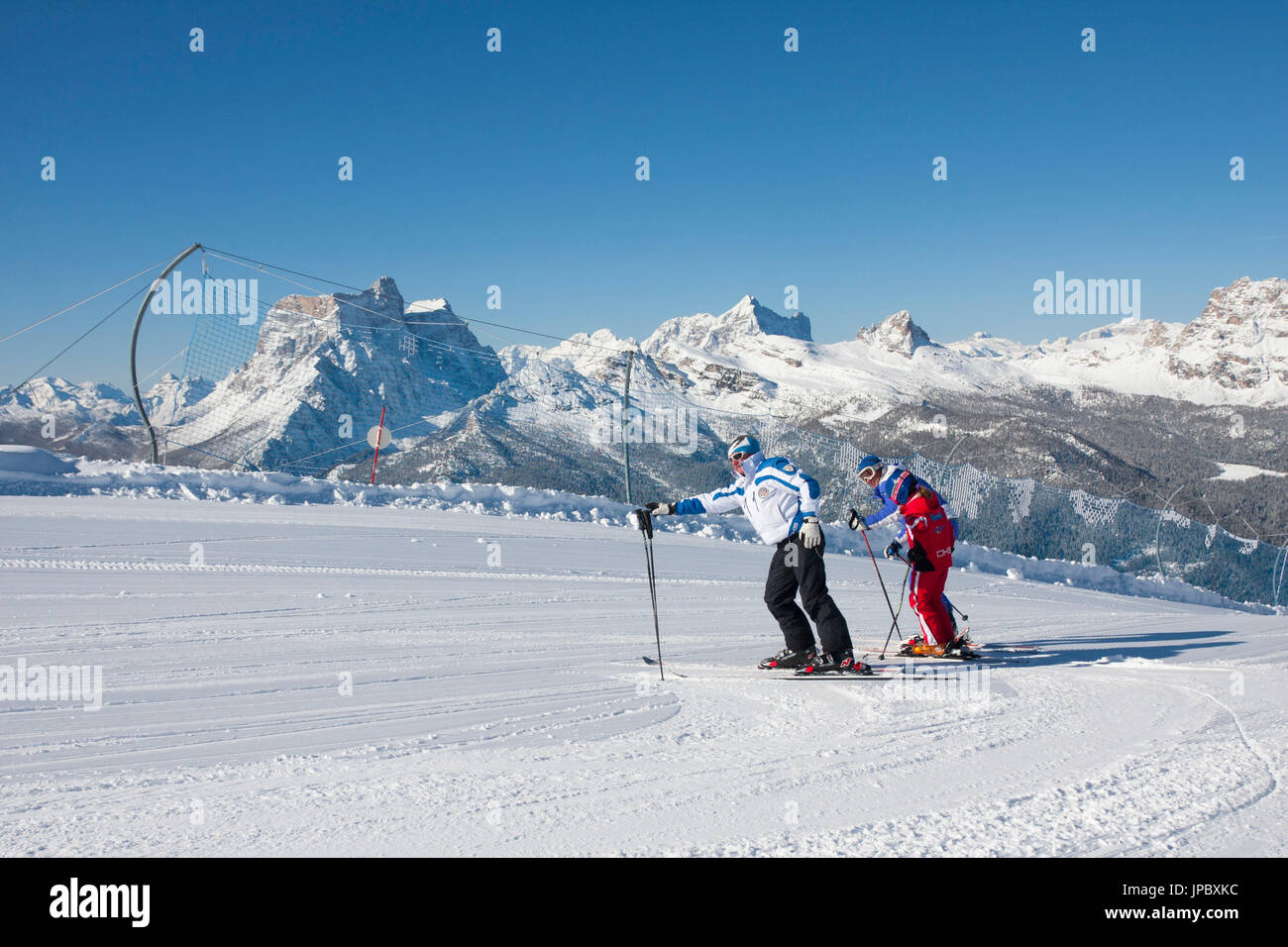 Skifahrer auf der Piste von Berg Faloria mit den schneebedeckten Gipfeln im Hintergrund Cortina d ' Ampezzo Dolomiten Venetien Italien Europa Stockfoto