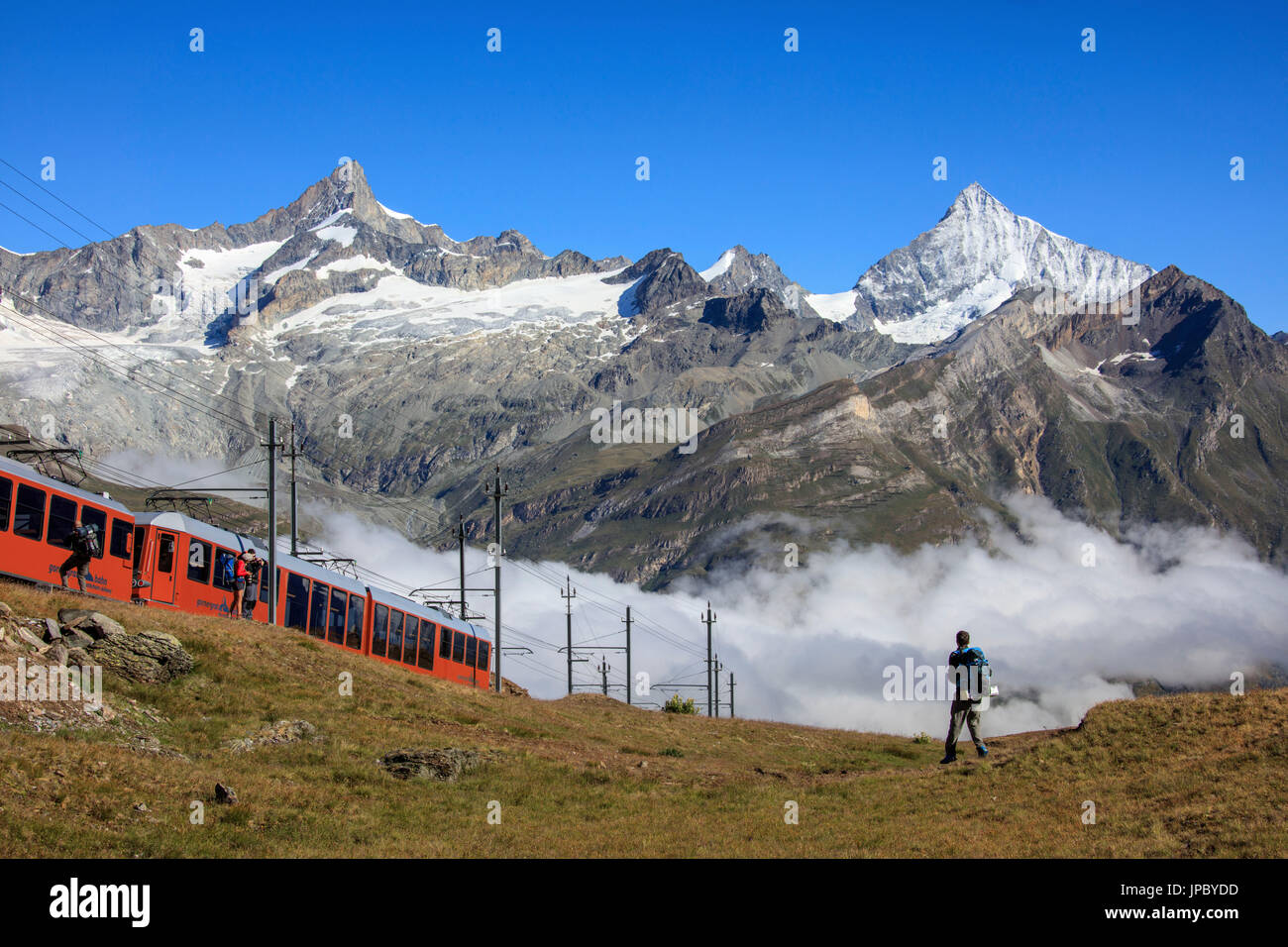 Wanderer und die rote Bahn trainieren mit der Gipfel der Dent Eringer im Hintergrund Gornergrat Kanton Wallis Schweiz Europa Stockfoto