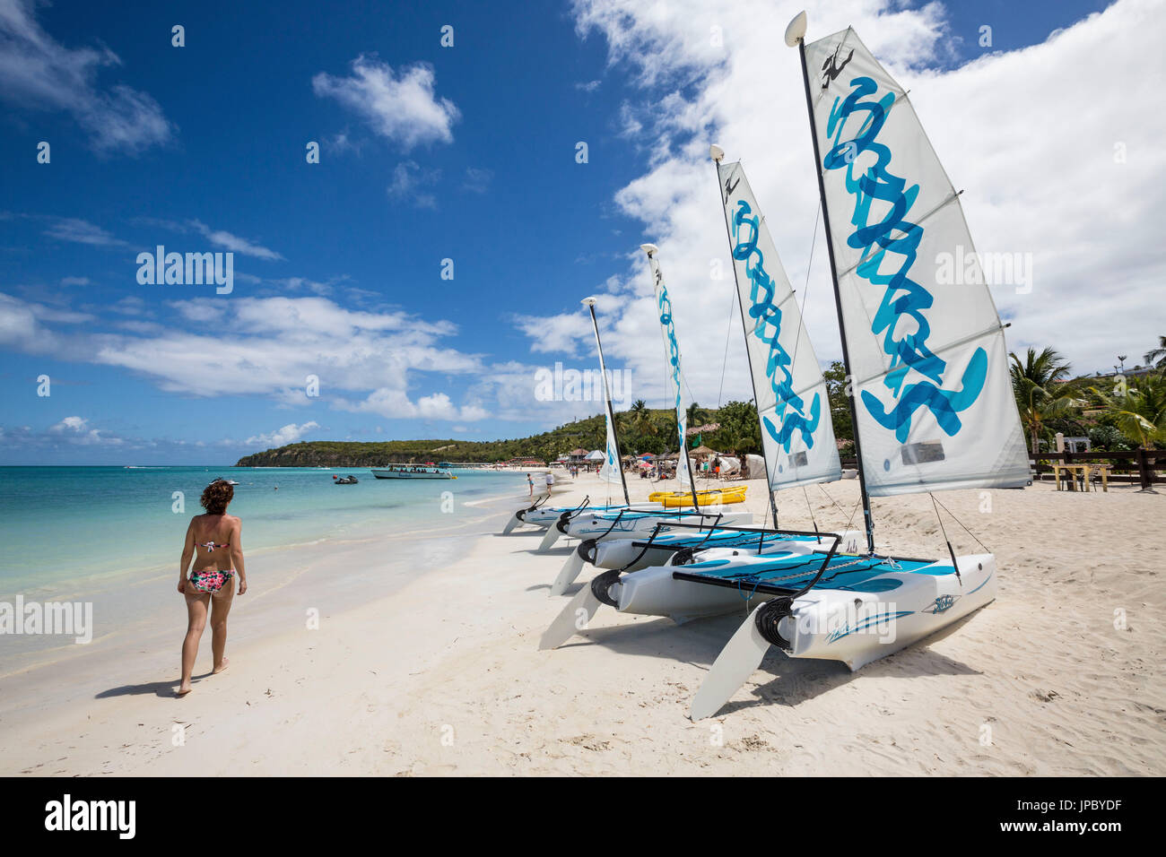 Ein Tourist auf dem sandigen Strand, ausgestattet mit Katamaranen Dickenson Bay Karibik Antigua und Barbuda Leeward Island West Indies Stockfoto