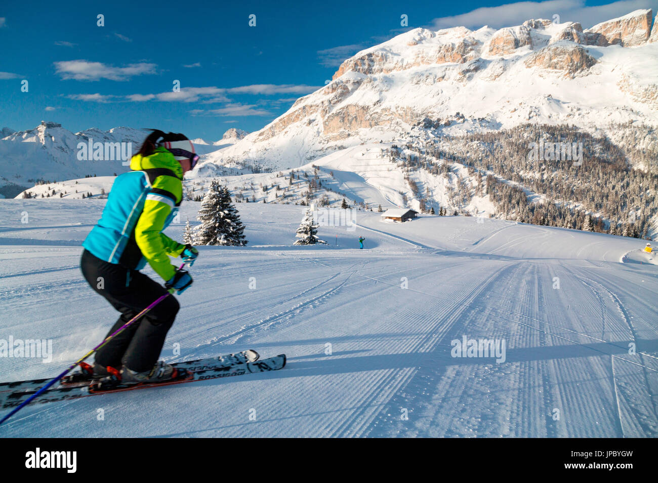 Blauer Himmel und Sonne umrahmen die Skifahrer auf den verschneiten Skipisten von Cherz Arabba Dolomiten Venetien Italien Europa Stockfoto