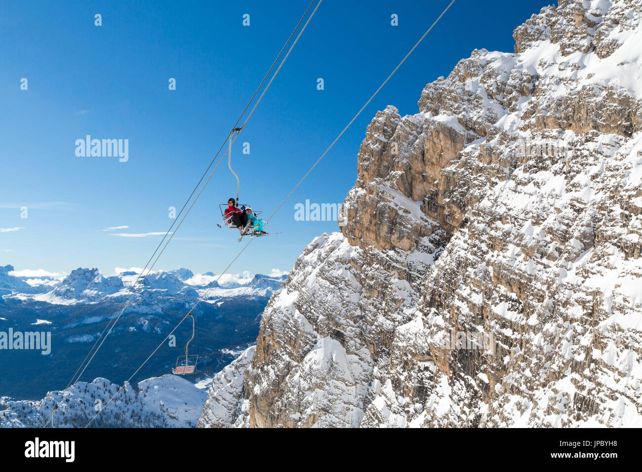 Blauen Himmel auf den Skifahrer auf Staunies Sesselbahn umgeben von felsigen Gipfeln der Dolomiten Cortina d ' Ampezzo Belluno Provinz Venetien Italien Europa Stockfoto