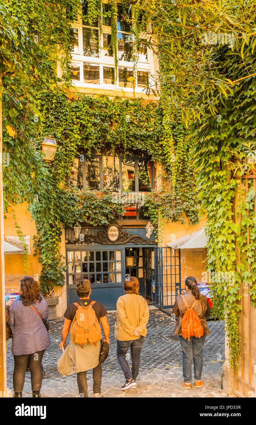 Touristen warten mit zugewachsenen Fassade der Osteria Margutta im Hintergrund Stockfoto