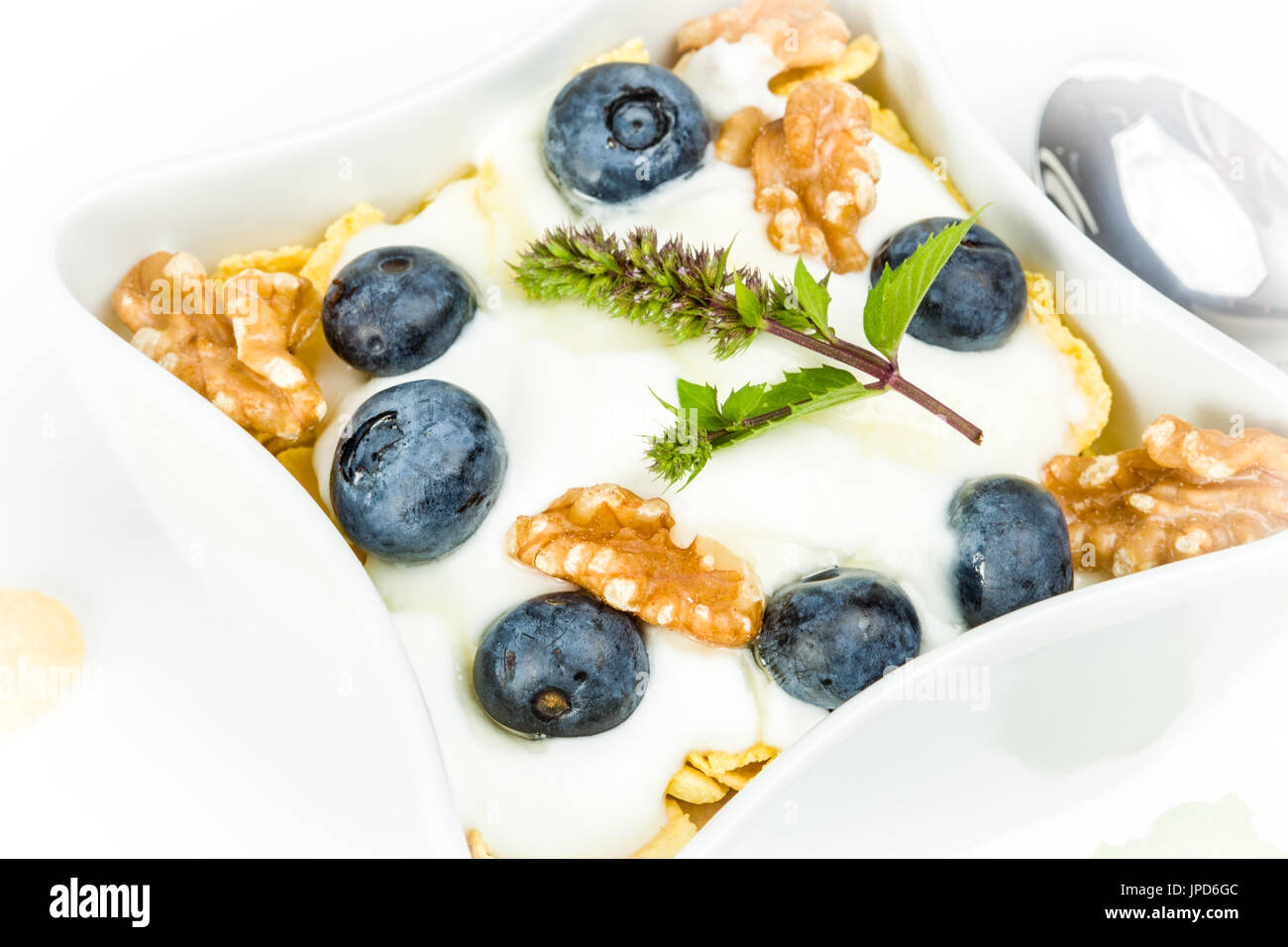 Corn Flakes mit Joghurt, Honig, Walnüsse und Heidelbeeren. Konzept von gesunden Lebensmitteln. Stockfoto