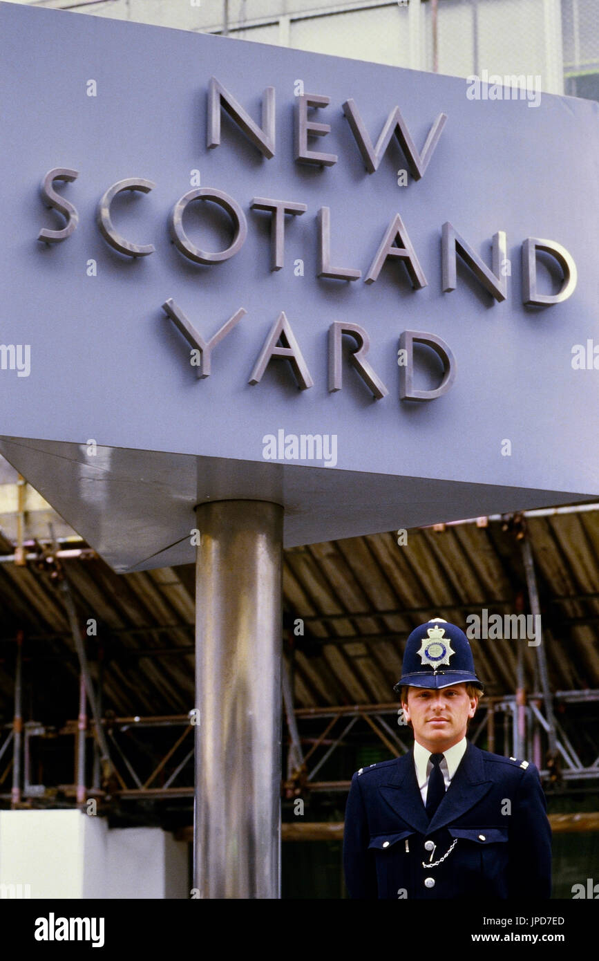 Ein Polizist steht neben dem Zeichen außerhalb der ehemaligen New Scotland Yard Gebäude, befindet sich in Victoria, London. England, UK, ca. 80er Jahre Stockfoto