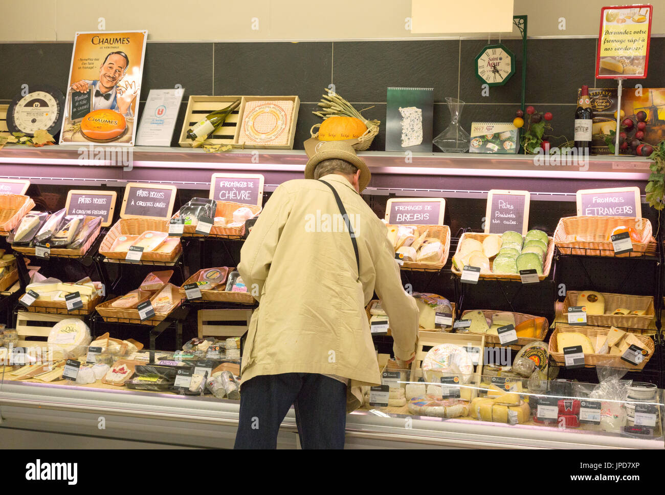 Ein Mann, der Käse an der Käsetheke in einem französischen Supermarkt zu kaufen, Bretagne, Frankreich Europa Stockfoto