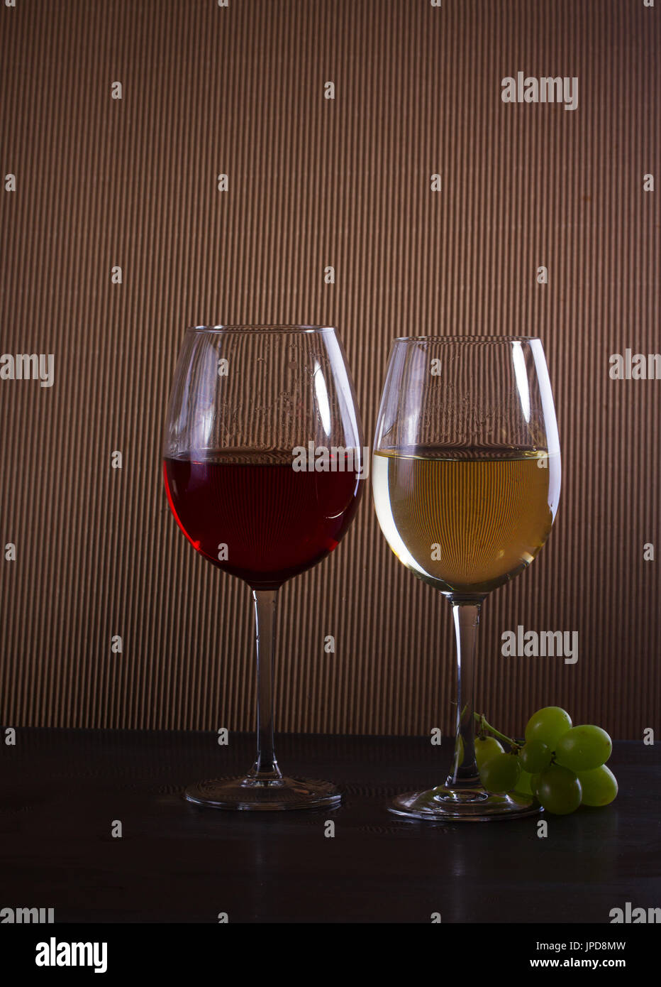 Gläser mit rot- und Weißwein auf Tisch, niedrige dunkle Schlüsselbild Stockfoto