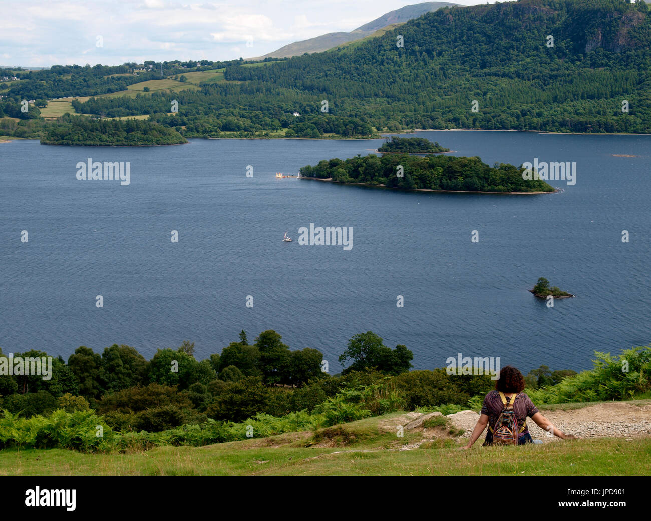 Frau saß ein Blick auf die Ansicht des Derwentwater, den Lake District, Cumbria, Großbritannien Stockfoto