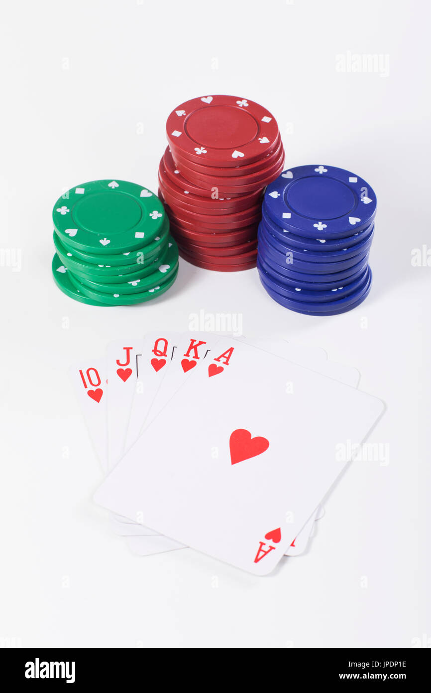 Stapel von grünen, roten und blauen Kunststoff Pokerchips oberhalb einer Hand einzigartige Spielkarten Stockfoto
