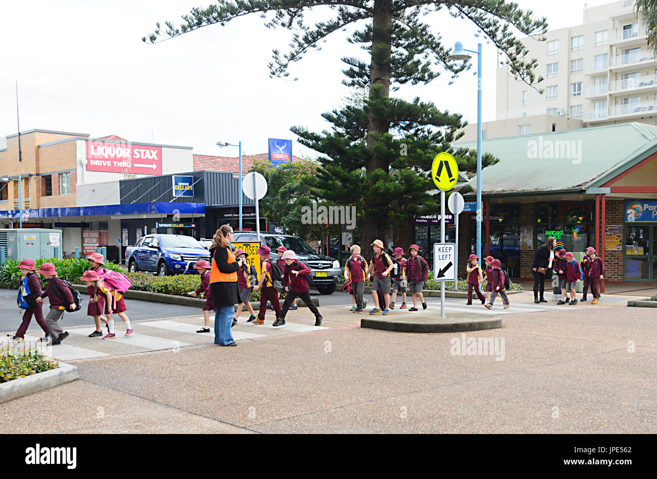 Schülerinnen und Schüler tragen ihre Schuluniform und überqueren einer Straße, Port Macquarie, New South Wales, NSW, Australien Stockfoto