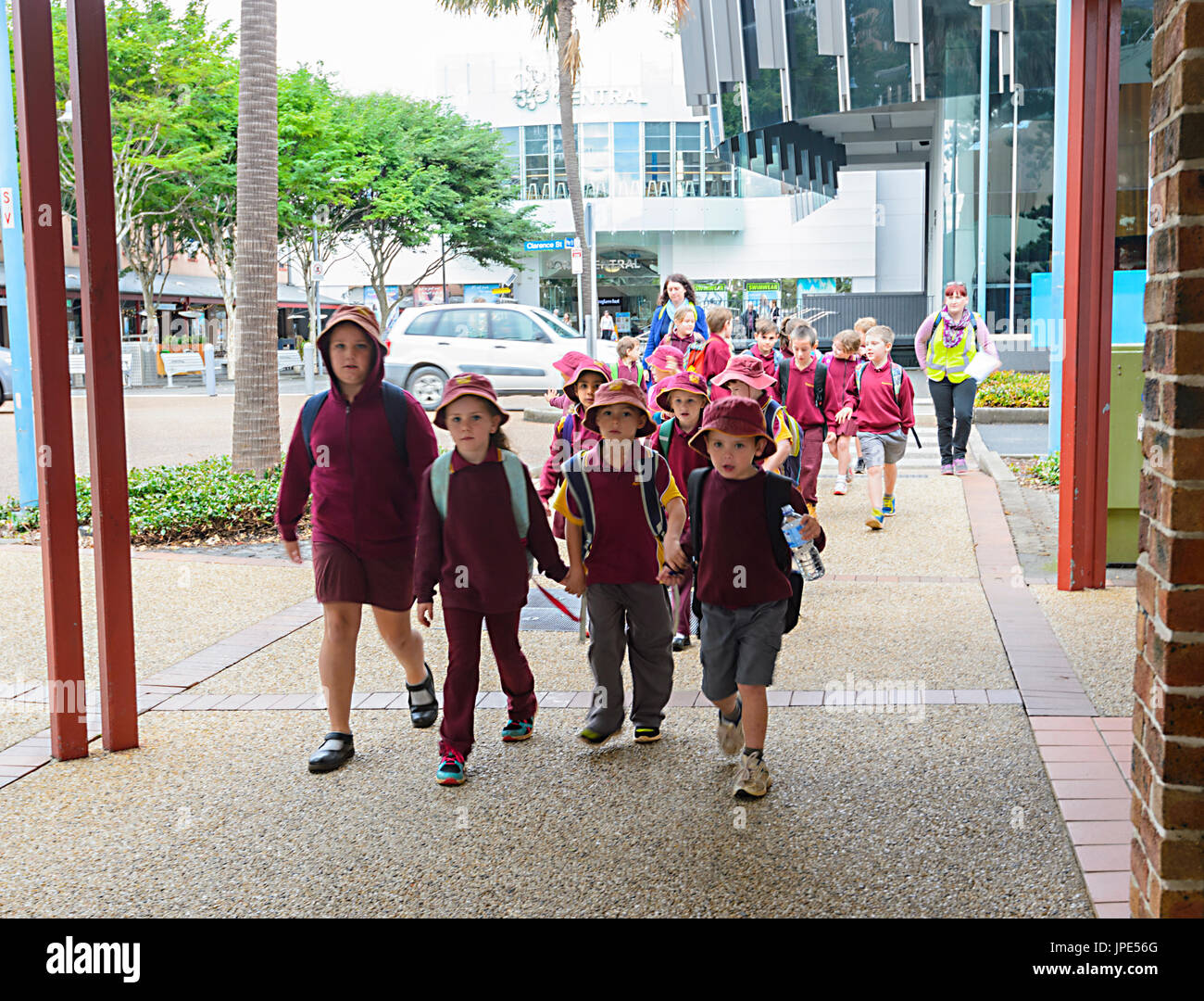 Schulkinder tragen ihre Schuluniform zu Fuß auf der Straße auf einen Schultag Ausflug, Port Macquarie, New South Wales, NSW, Australien Stockfoto