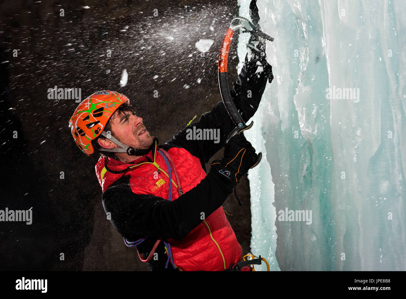 Dolomiten, Fassatal, Italien, Europa, Trentino, Alpen. Eis-Kaskaden, klettert ein Mann mit einem Eispickel, Eisblock eingefroren in den europäischen Alpen. Stockfoto