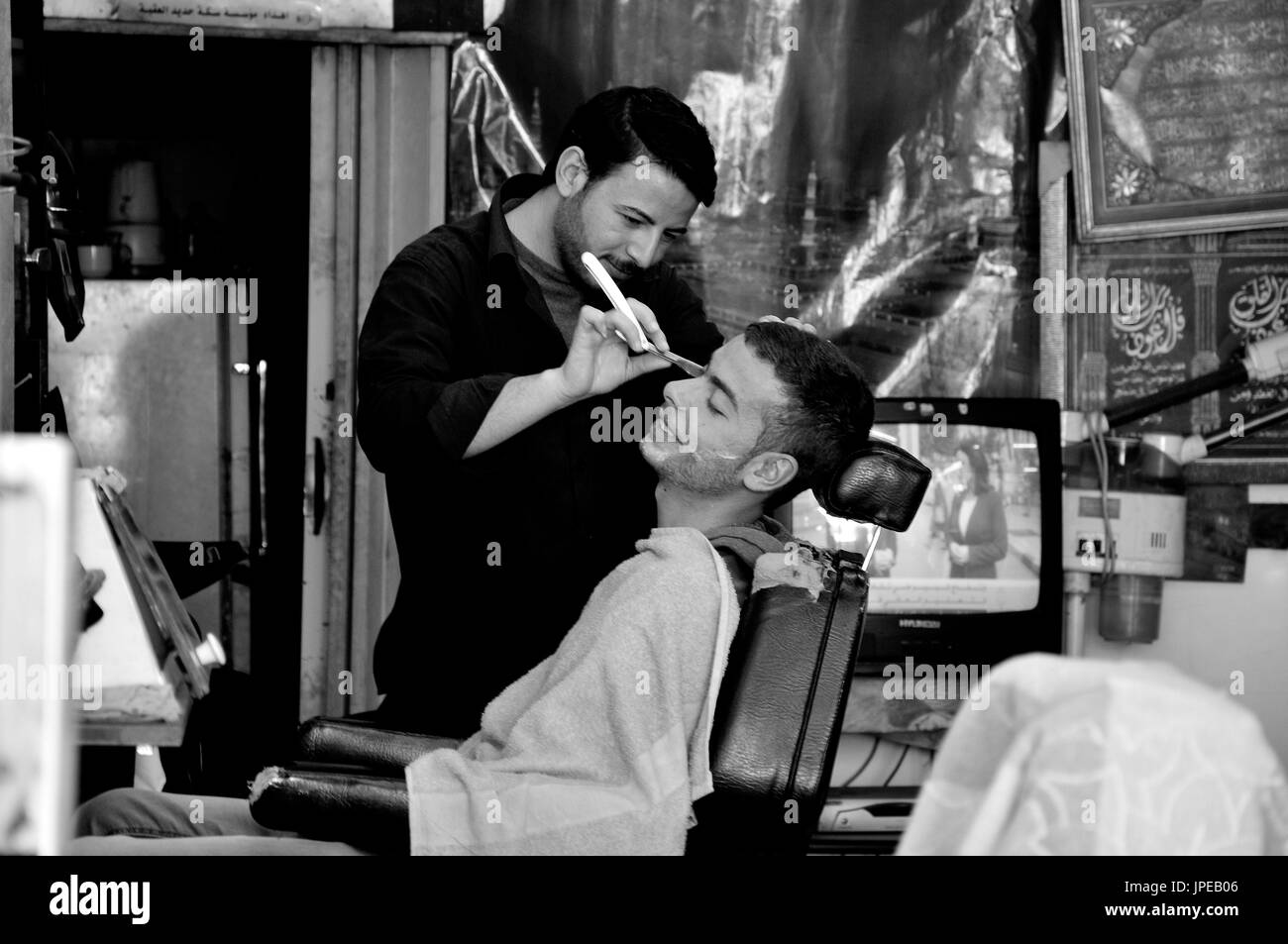 Jordanien. Ein Friseur ist bei der Arbeit in seiner kleinen Werkstatt Stockfoto