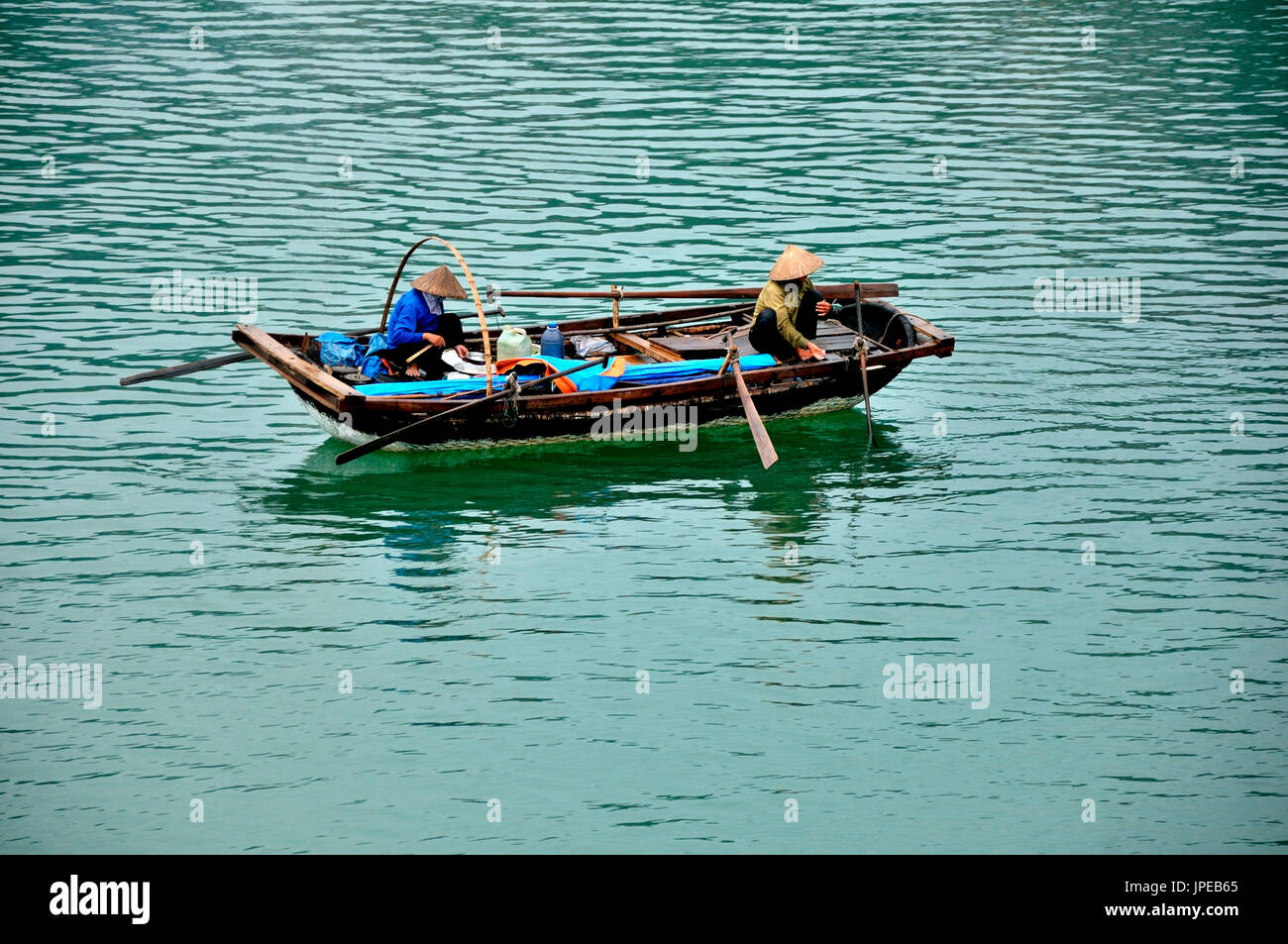 Vietnam, Ha-long-Bucht. Zwei Fischer auf ihren typischen Boot. Stockfoto