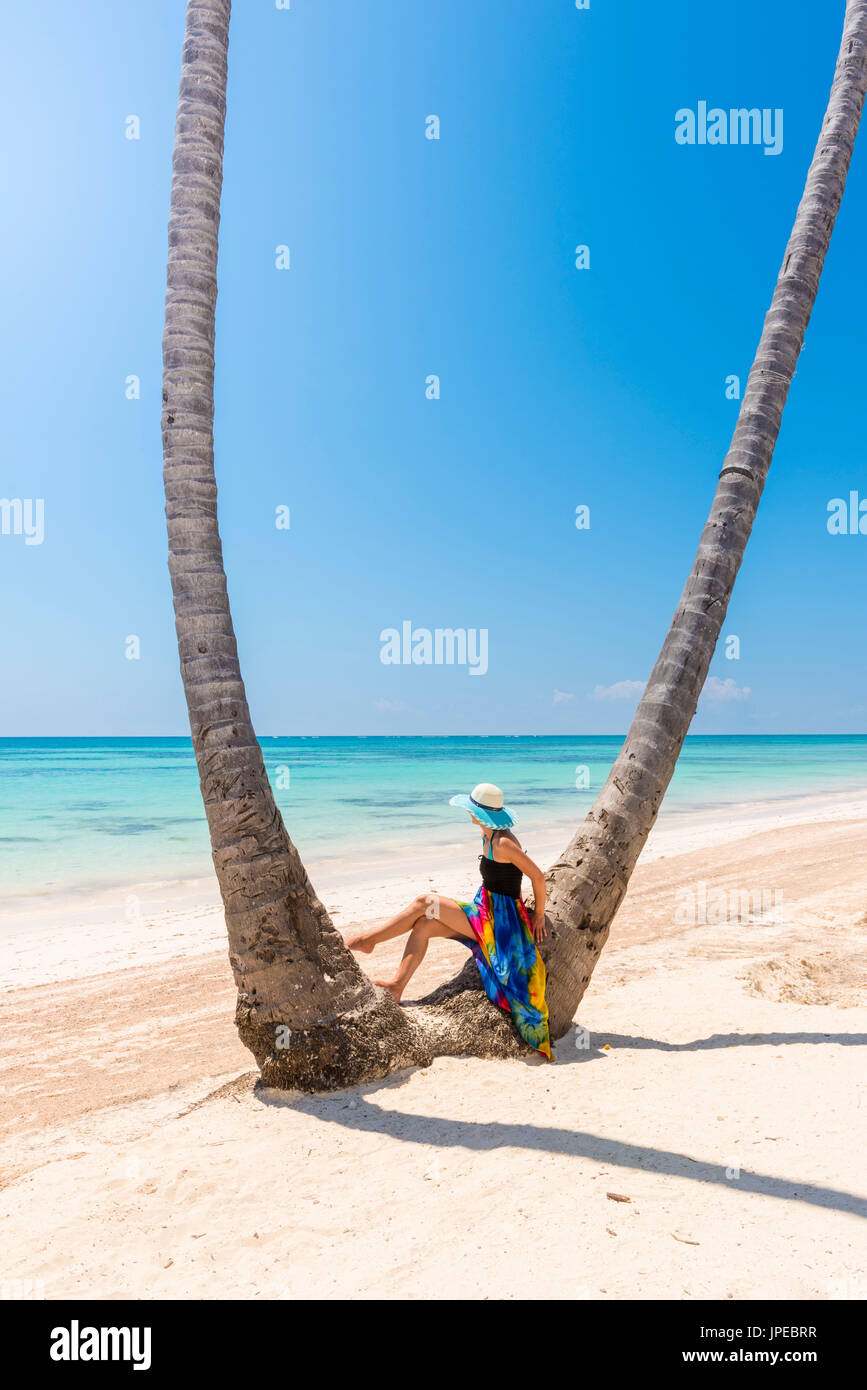 Juanillo Strand (Playa Juanillo), Punta Cana, Dominikanische Republik. Frau unter hohen Palmen am Strand (MR) Stockfoto